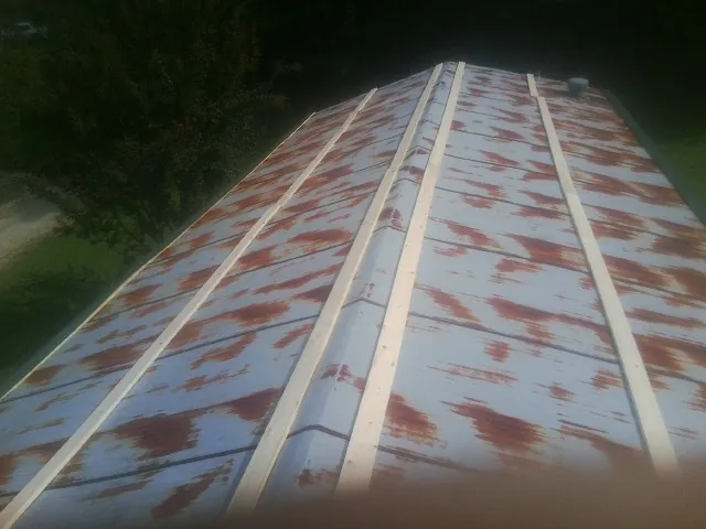 Rusted metal roof panels with new wood purlins before replacement — Storm Damage Roof Repair in Summerland by Roofing Brothers