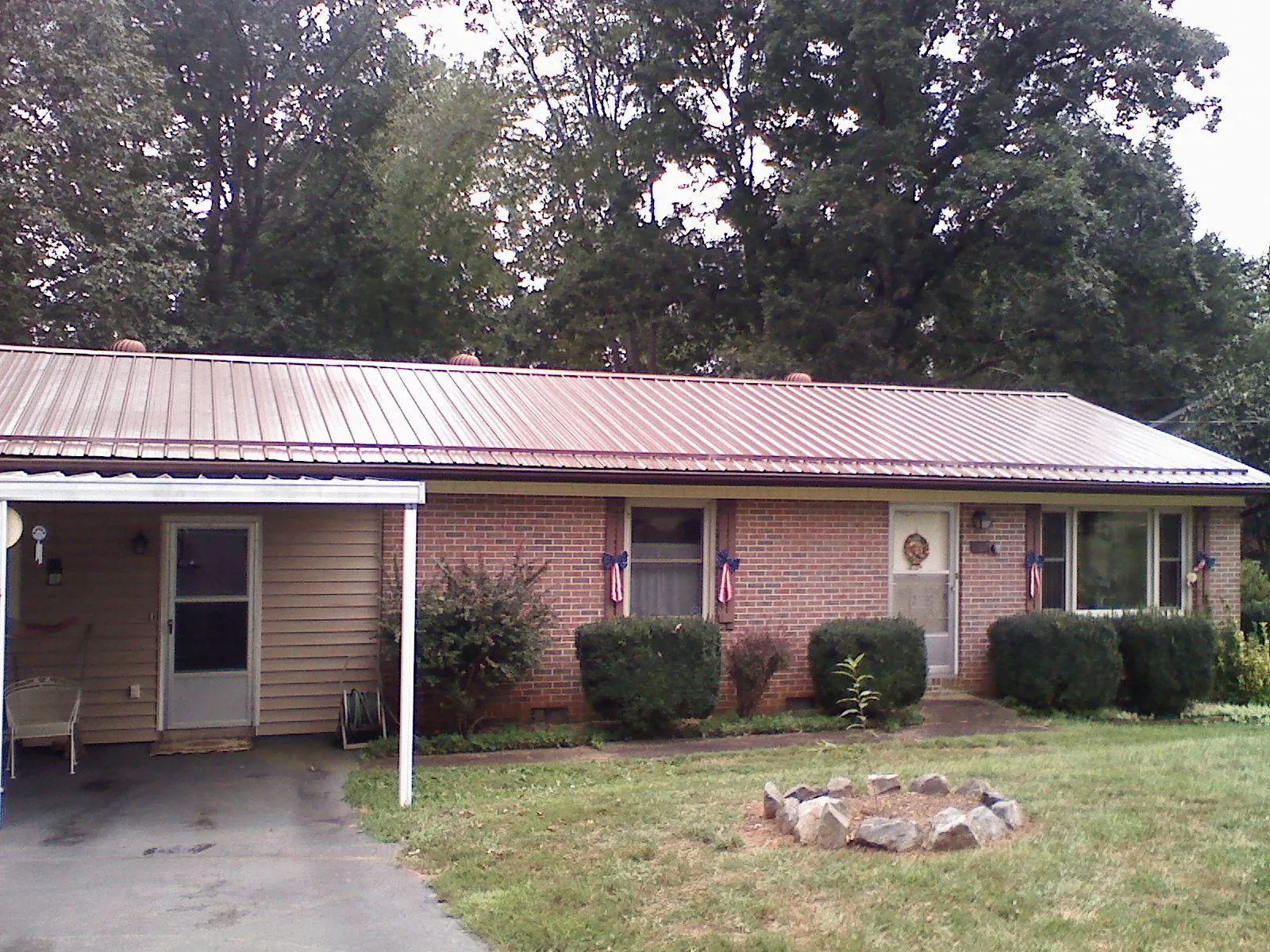 Bronze metal roof and carport on a brick ranch home — Roof Repair work by our crew in Summerland