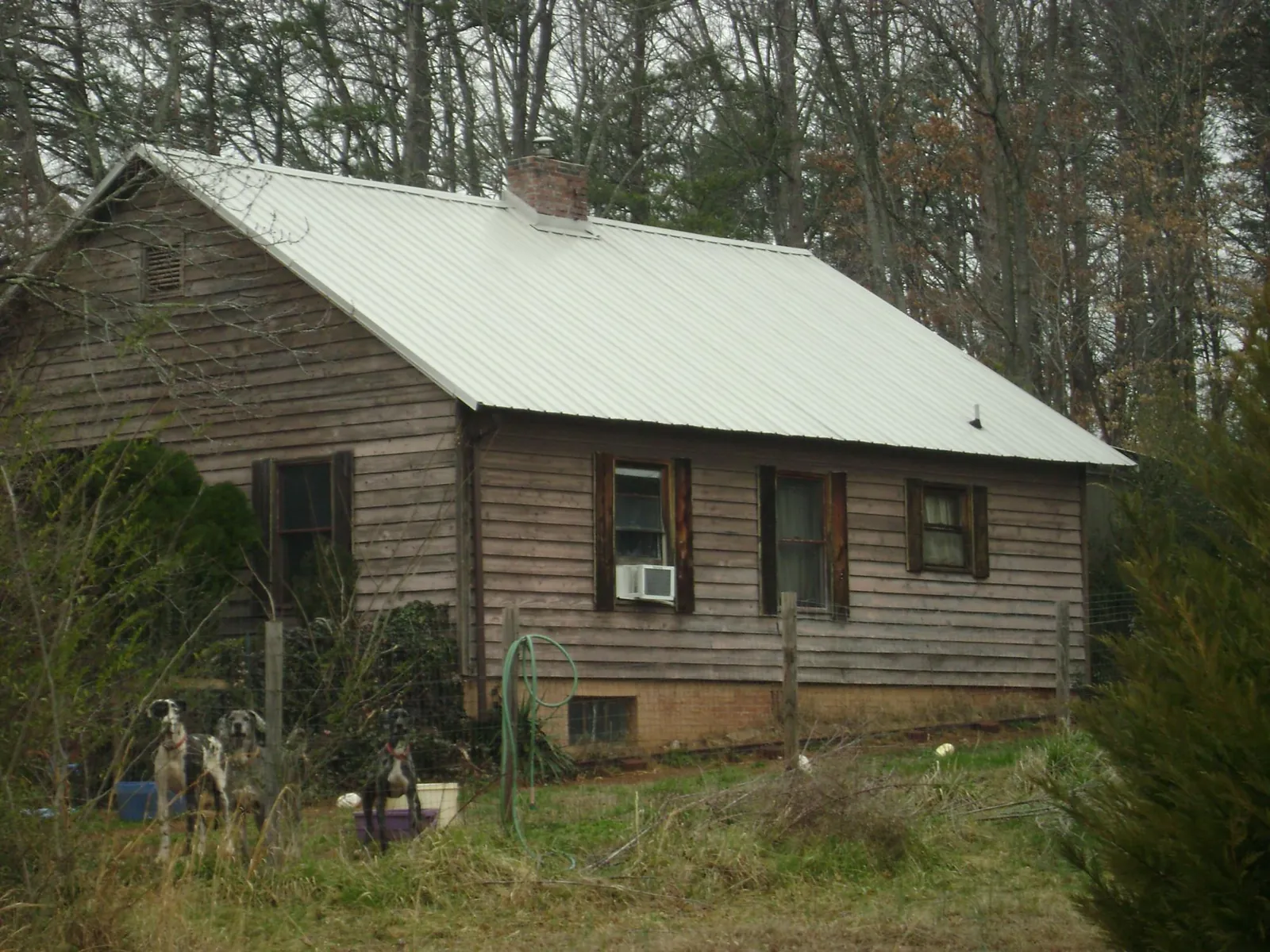 White metal roof on an old wood sided farmhouse, from a Metal Roof Installation job in Summerland